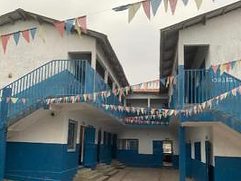Bâtiment bleu et blanc du Site I à Massengo, avec escaliers et fanions